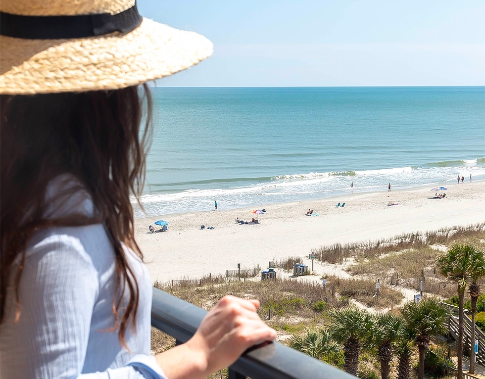 a woman looking at the beach