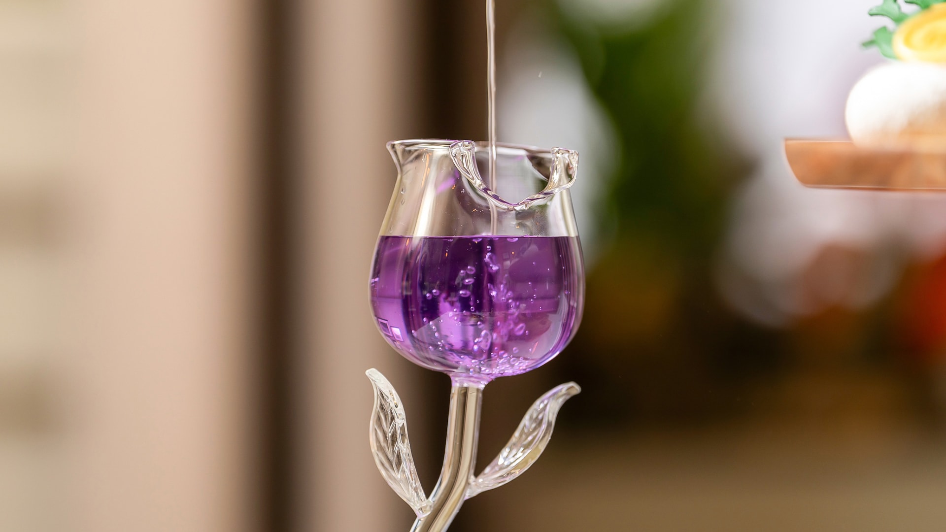 a glass with purple liquid being poured into it