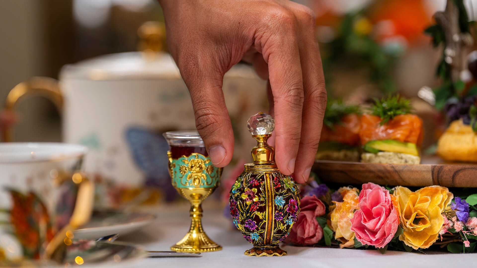 a hand holding a small glass with a handle