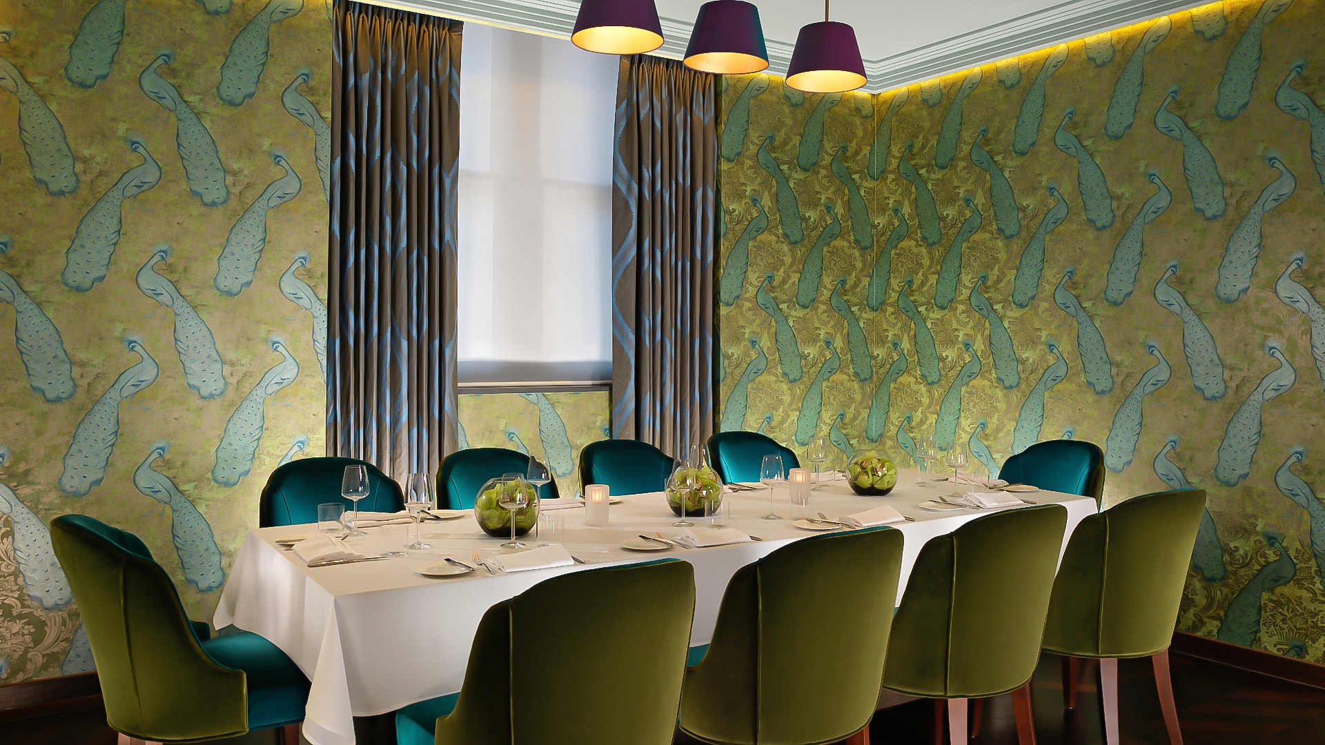 a room with a table set with green chairs and a white tablecloth