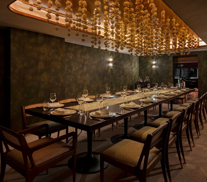 a long table with plates and glasses in a room with chairs