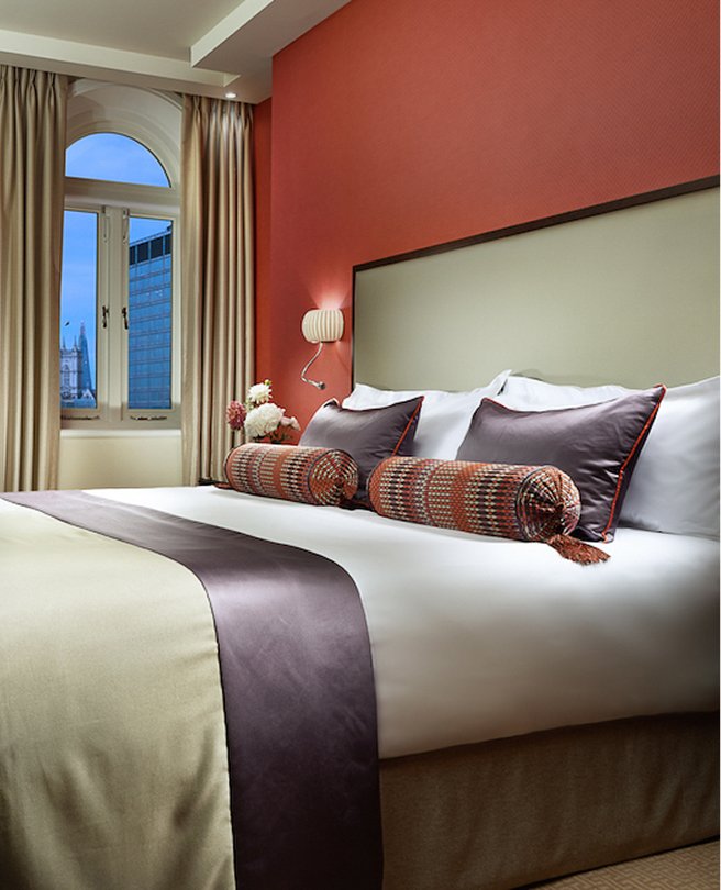 a bed with pillows and a lamp in a room
