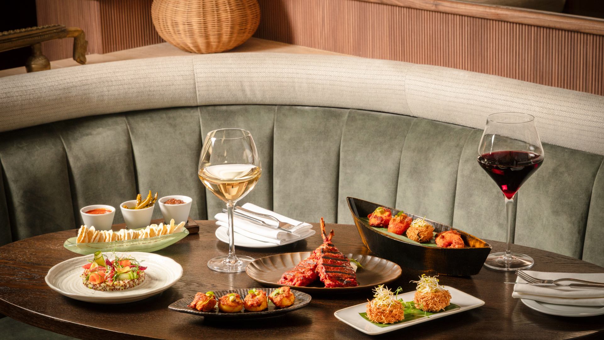 a table with plates of food and a glass of wine