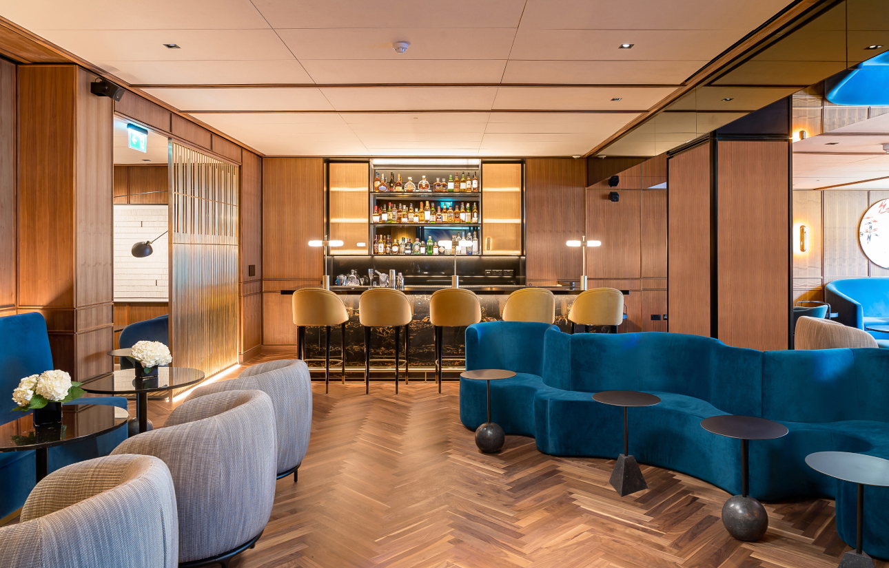 a room with a bar and a blue couch