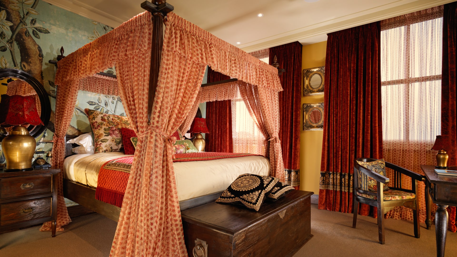 a bed with a canopy in a room with red curtains