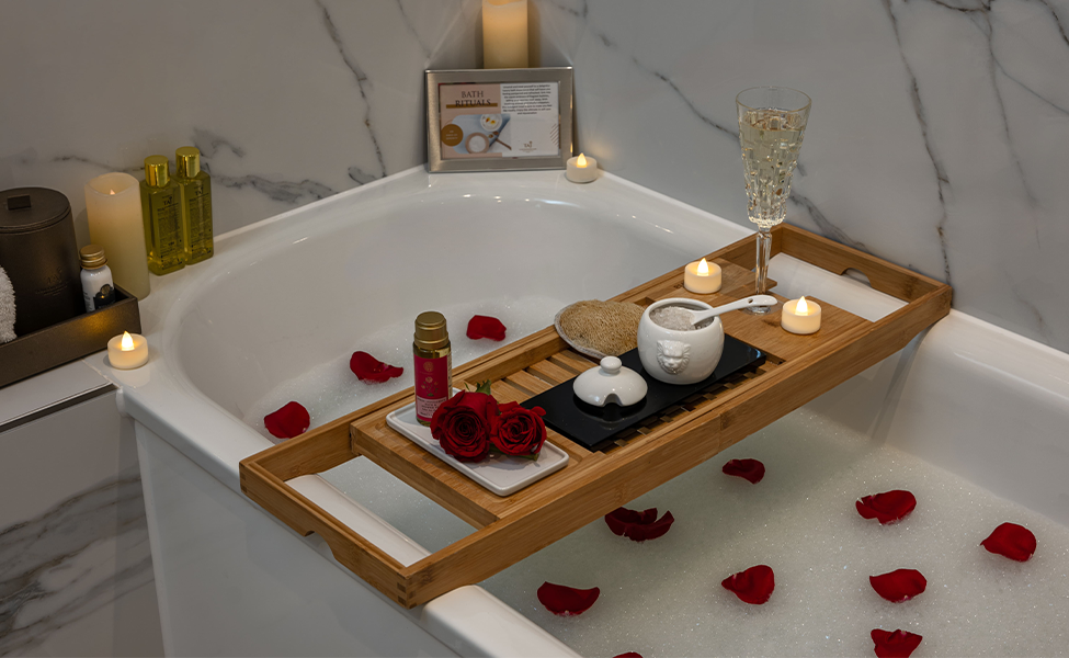a tray with candles and flowers on it in a bathtub