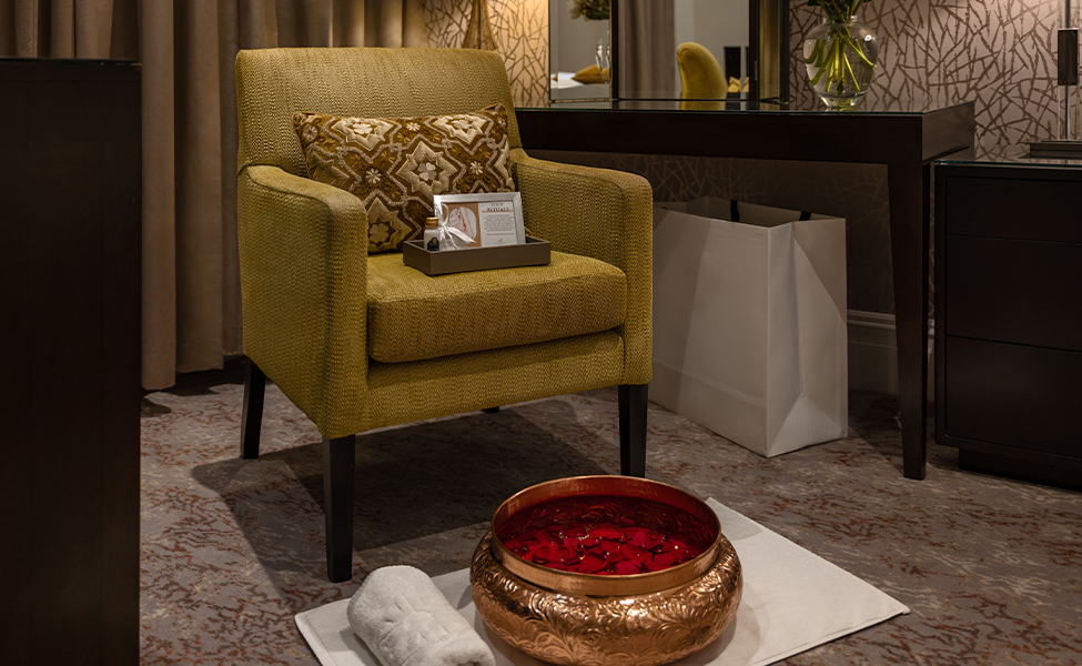 a chair with a bowl of red liquid and a towel on the floor