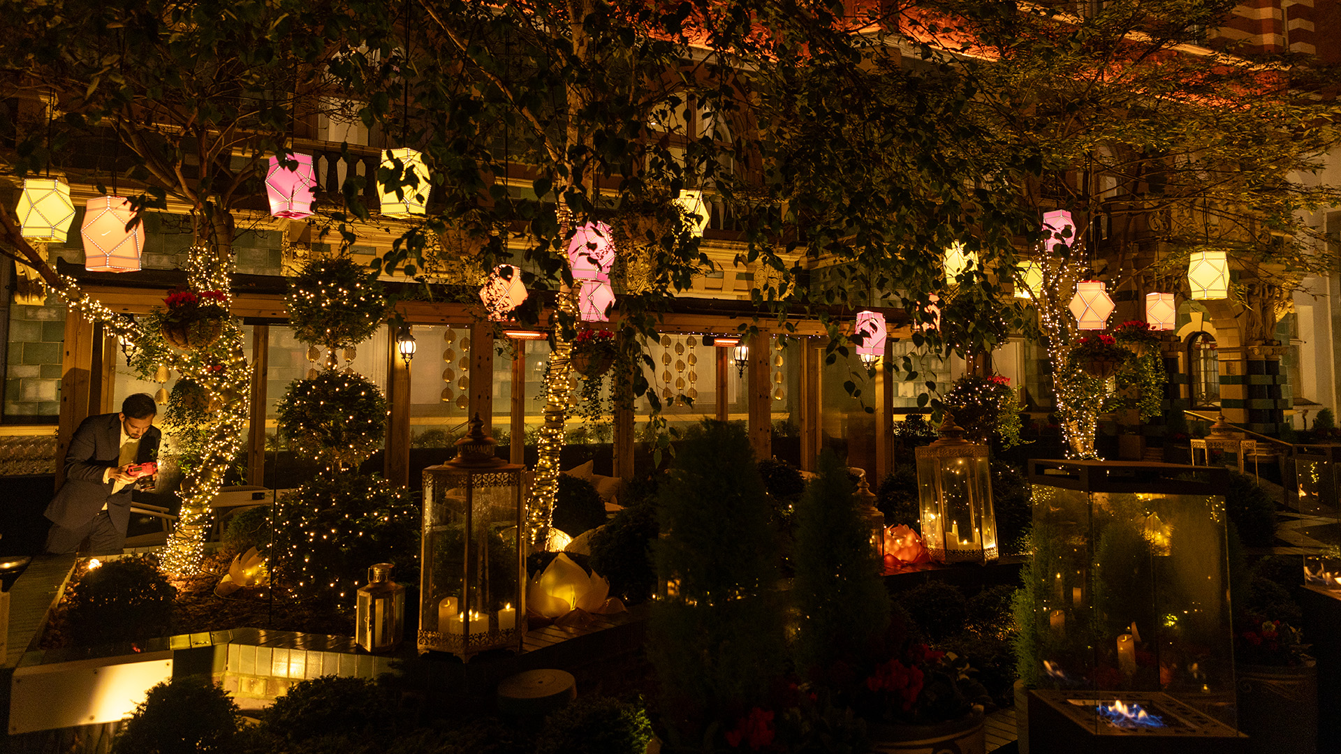 a building with trees and lanterns at night