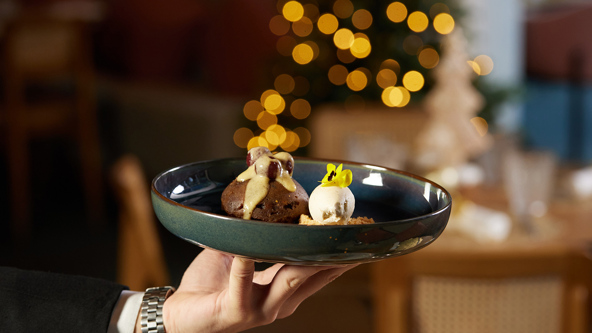 a hand holding a plate of dessert