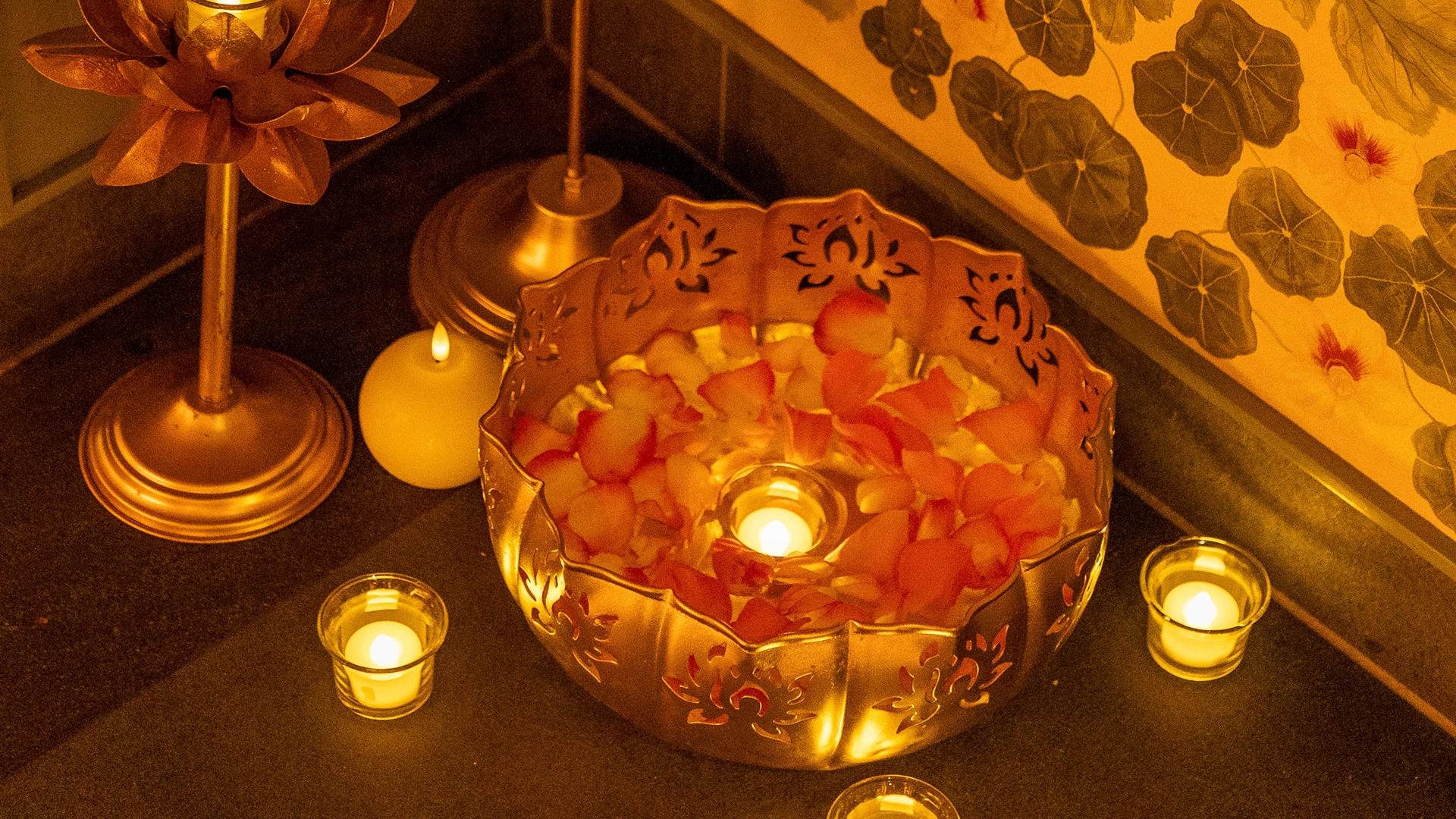 a bowl with rose petals and candles