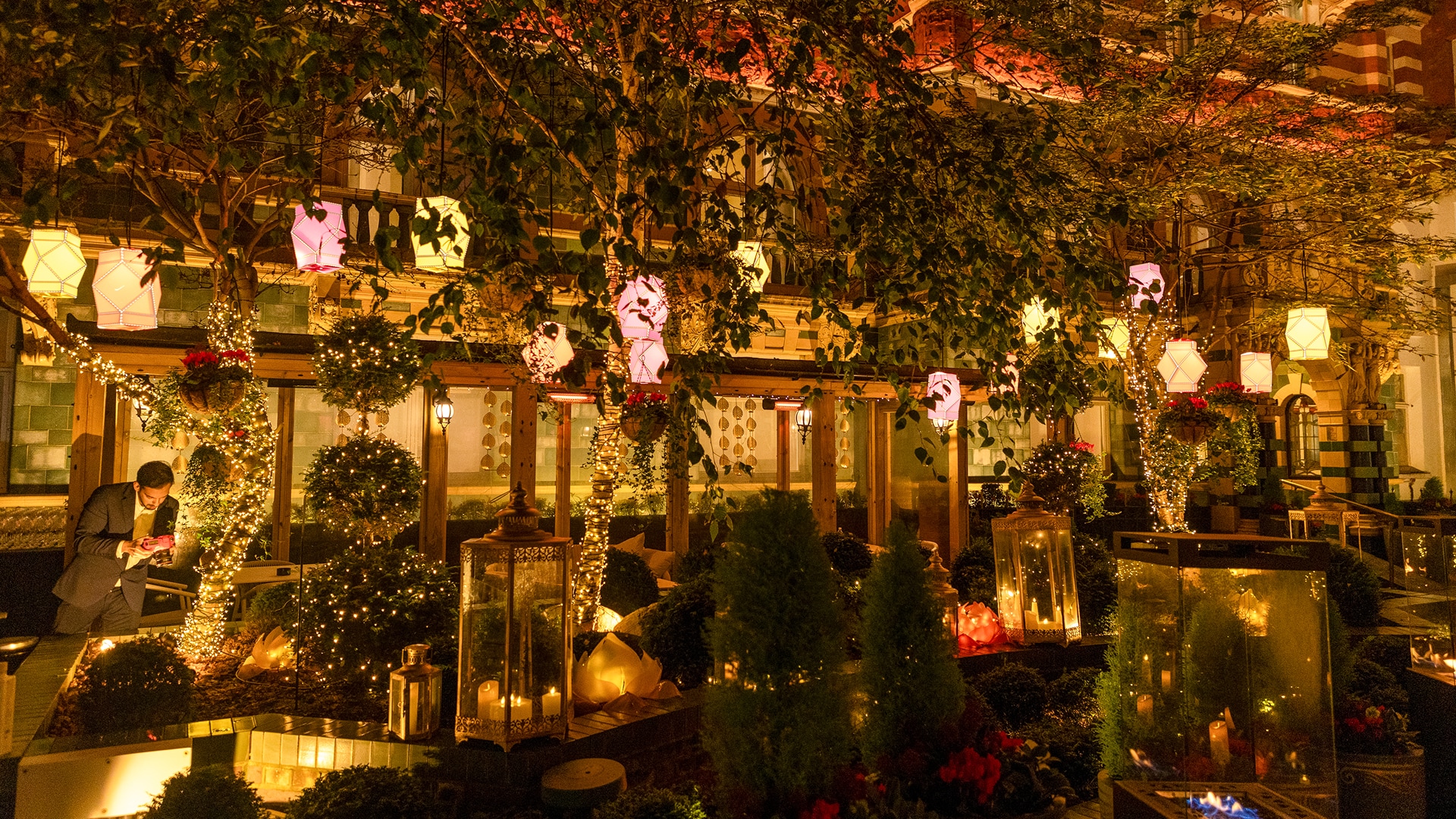 a building with trees and lanterns at night