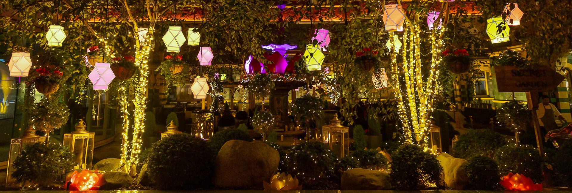 a garden with lanterns and trees