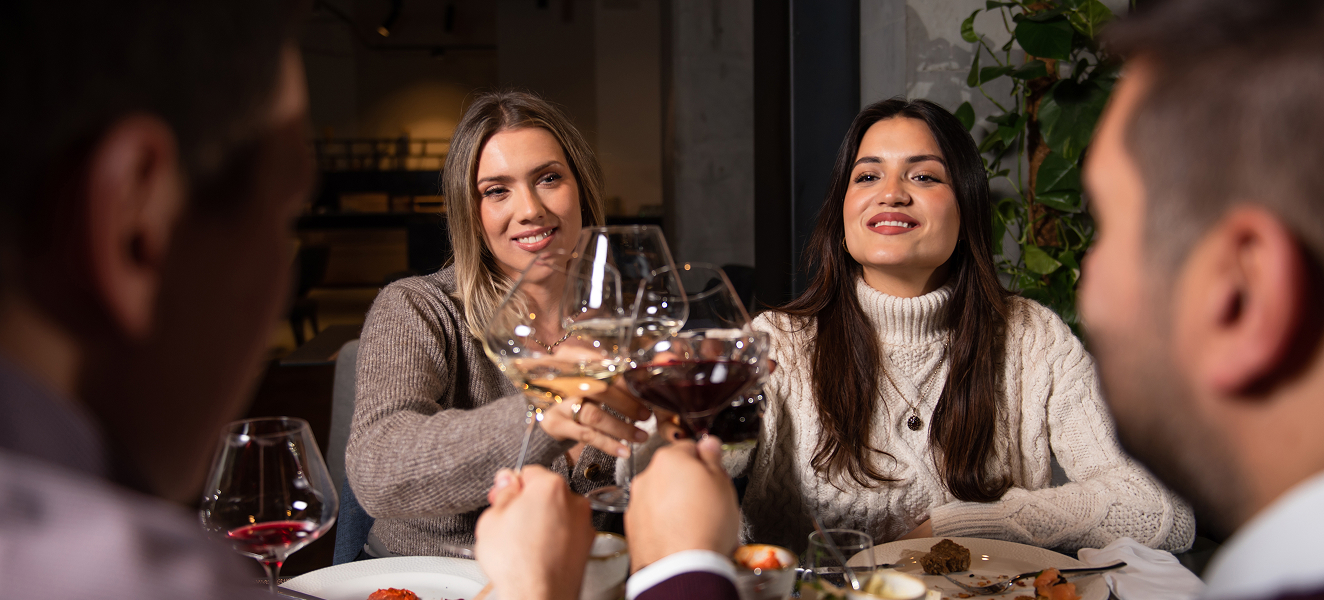 a group of women sitting at a table with wine glasses