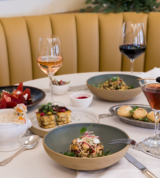 a table with plates of food and wine glasses