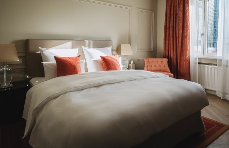 a bed with pillows and a chair in a room