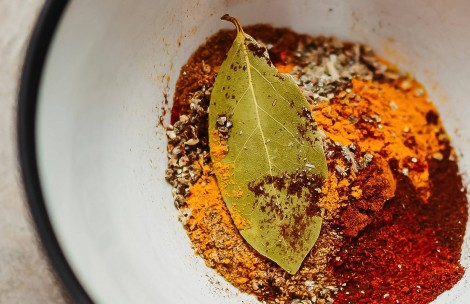 a bowl of spices and a leaf