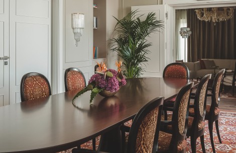 a table with chairs and a vase of flowers