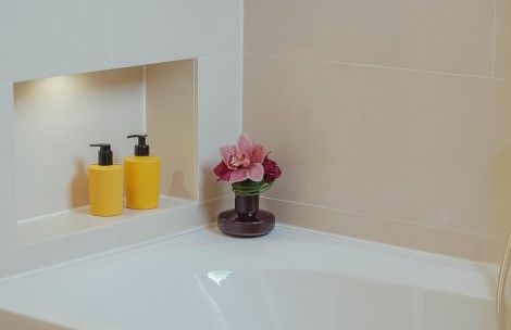 a flower in a vase on a bathtub