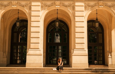 a woman sitting on steps in front of a building