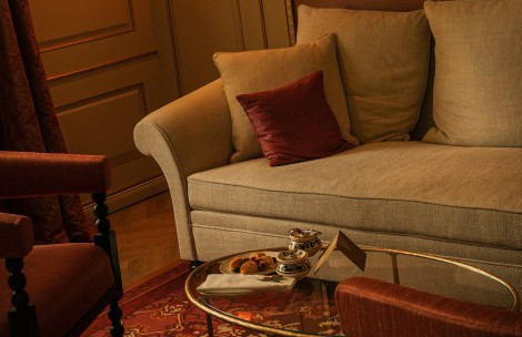 a couch with a tray of food on a glass table