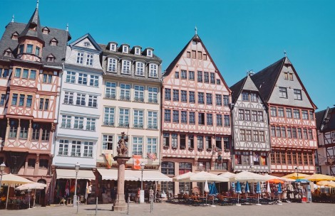 a group of buildings with a statue in front of them with Römer in the background