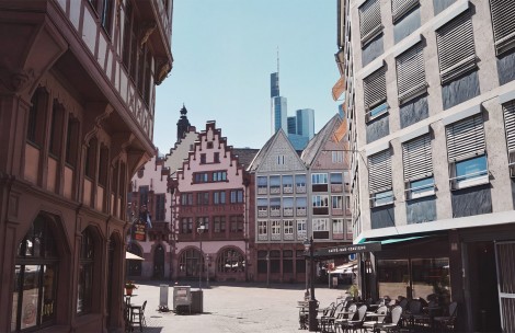 a city square with buildings and a tall building in the background