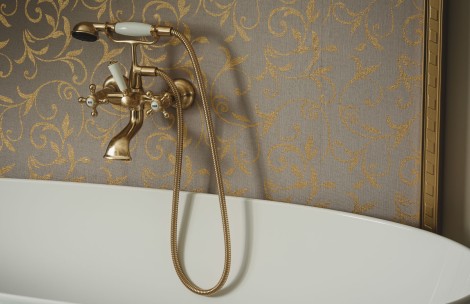 a gold faucet with a hose attached to a bathtub