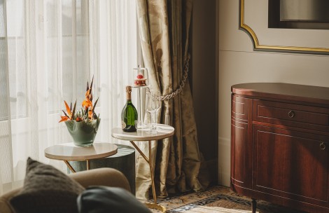 a table with a bottle of champagne and a vase of flowers on it