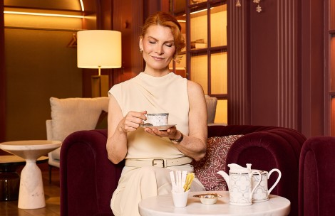 a woman sitting in a chair holding a tea cup