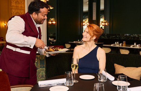 a man serving a woman at a restaurant