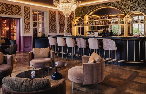 a bar with chairs and a chandelier