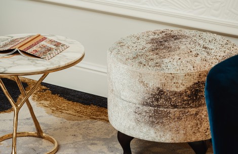 a round stool next to a table