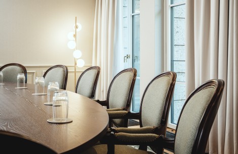 a table with chairs and a lamp in front of windows