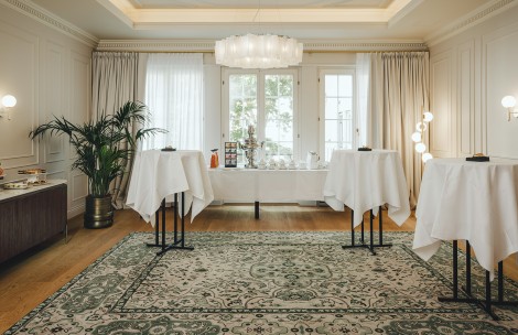 a room with tables and chairs and a rug