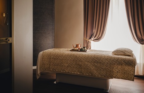 a bed with a tray of tea and a tray of coffee
