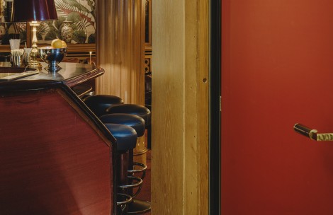 a bar with stools and a red wall