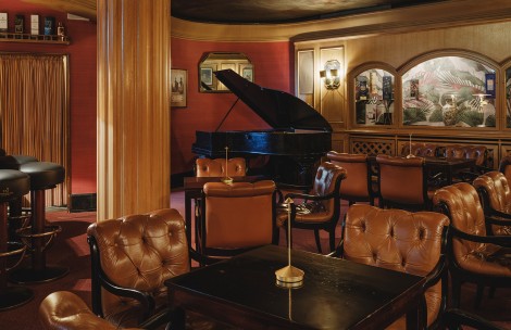 a room with a piano and chairs