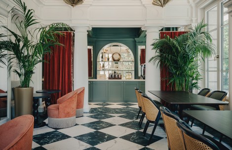 a room with a checkered floor and chairs and a bar