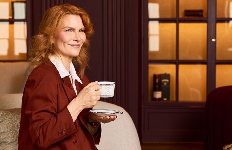 a woman holding a cup and saucer