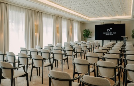 a room with many chairs and a screen