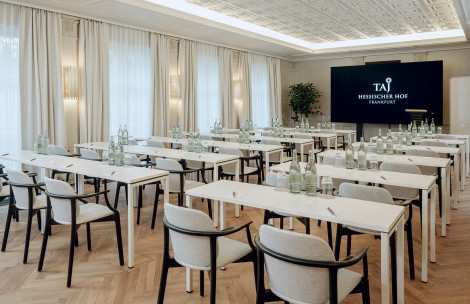 a room with tables and chairs and a screen