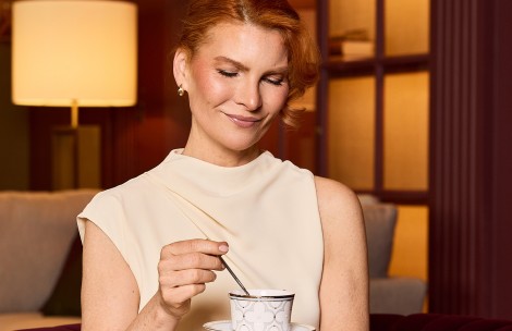 a woman holding a spoon and a cup