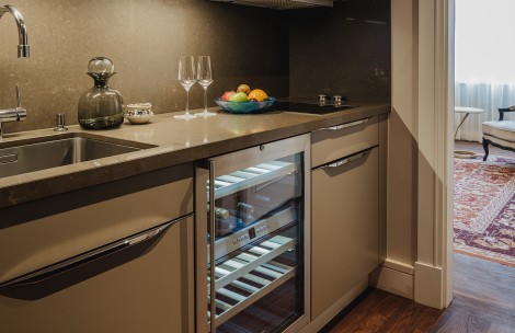 a wine fridge with wine glasses and fruit on it