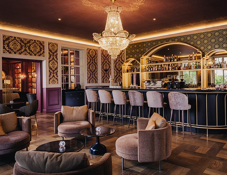 a bar with chairs and a chandelier