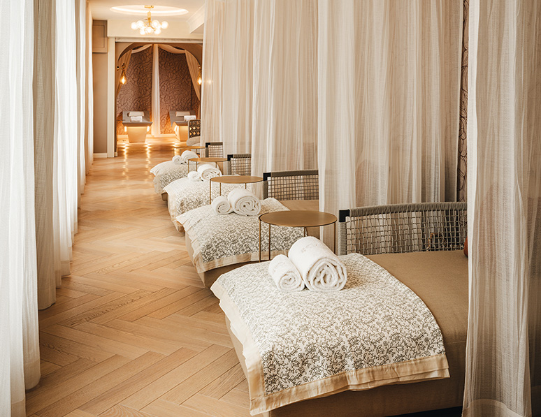 a room with white curtains and beds