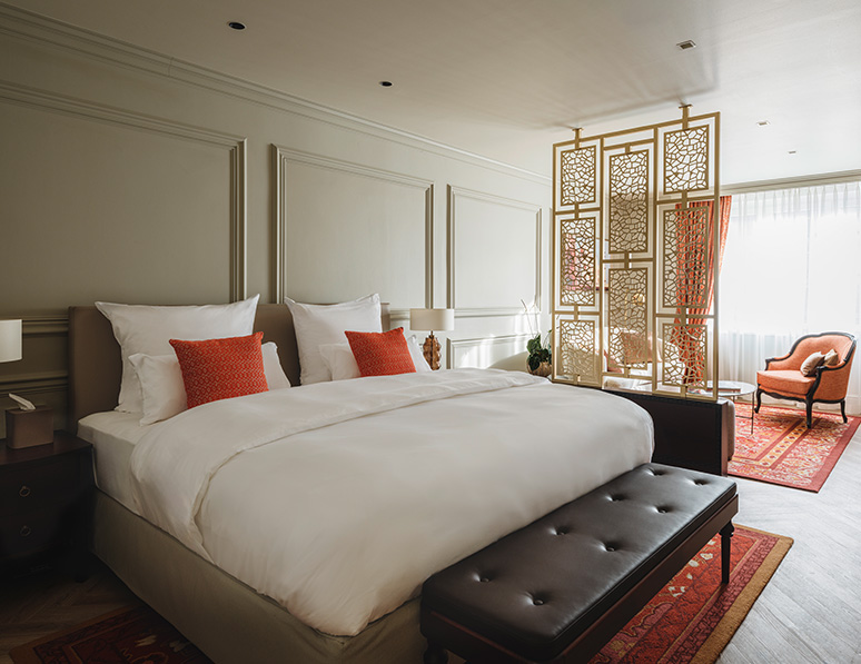 a bed with pillows and a bench in a room
