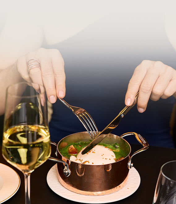 a person eating food with a glass of wine