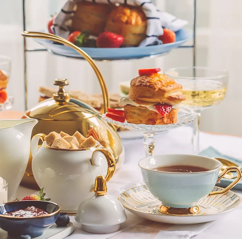 a table with tea cups and desserts