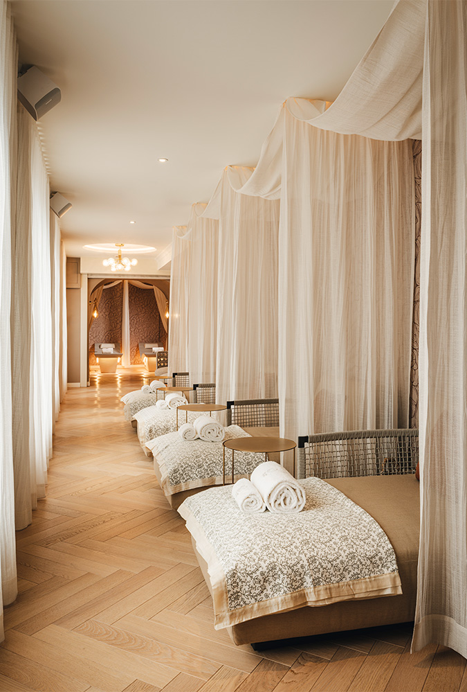 a room with white curtains and beds