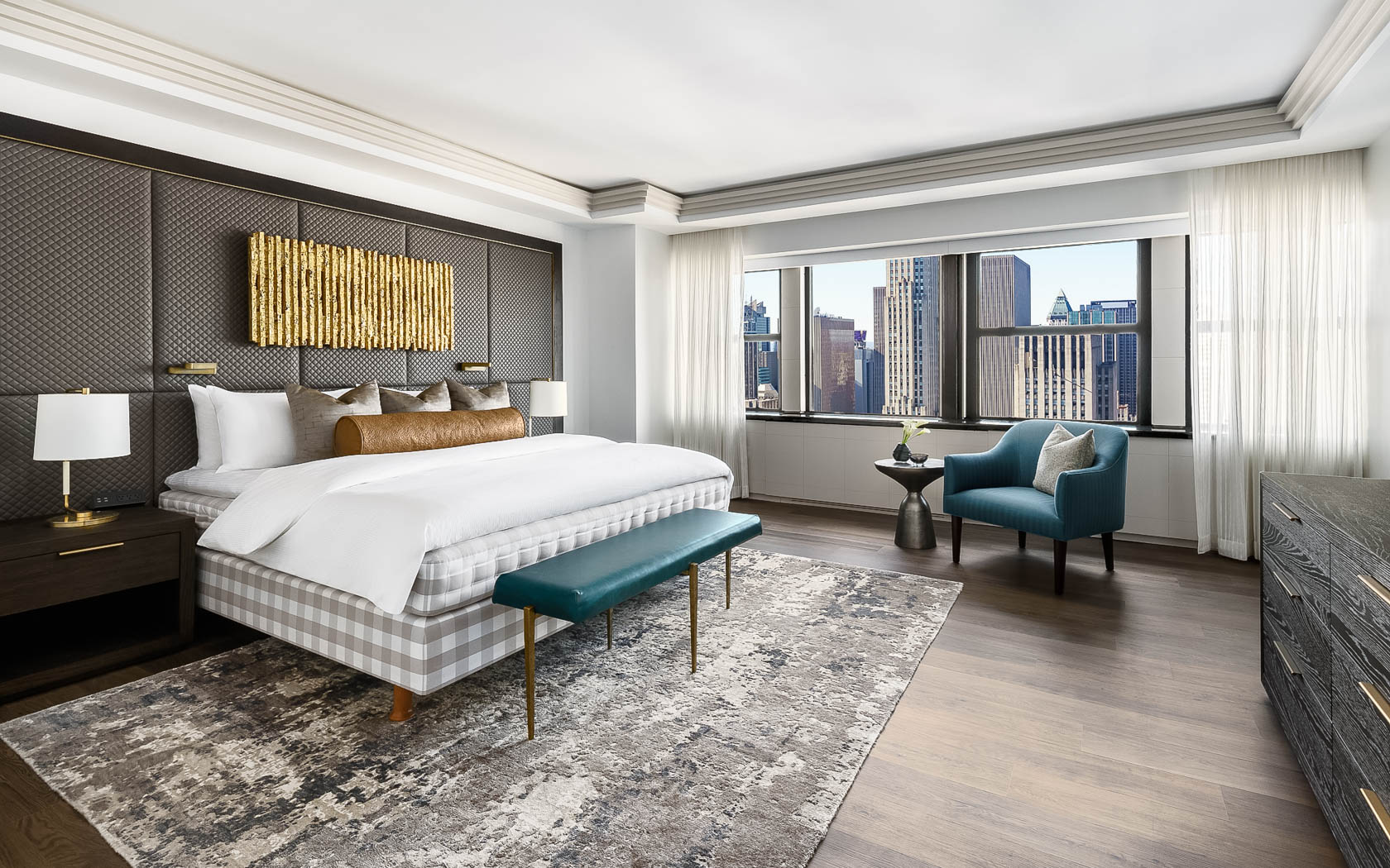 a bedroom with a large bed and a blue chair